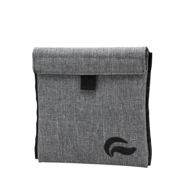 The Skunk Mr Slick 6” Stash Storage Case is a gray carbon fabric pouch with a fold-over flap and black tab, featuring a black abstract logo. Its airtight carbon lining eliminates odors for discreet storage of smelly items.